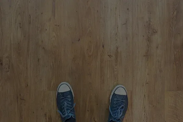 Trägolv sett uppifrån med ett par sneakers